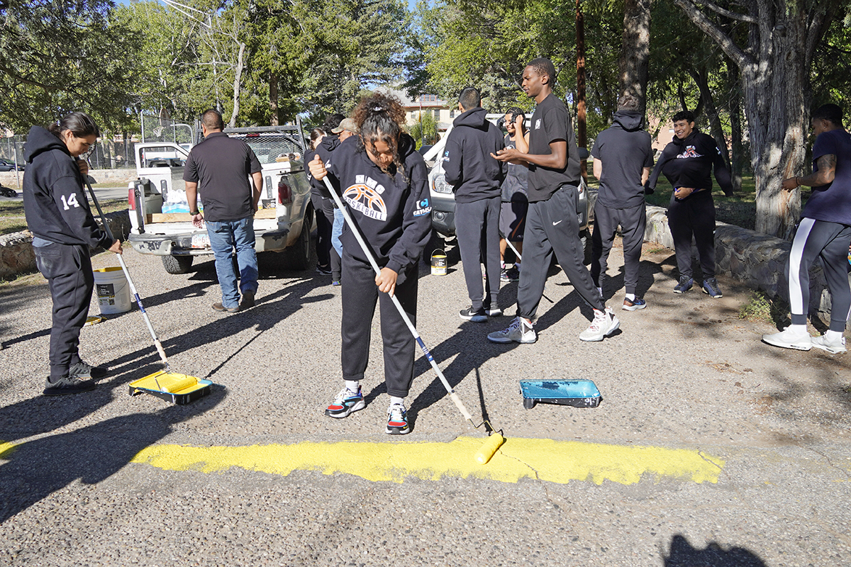 Northern Athletes painting El Rito speed bumps.